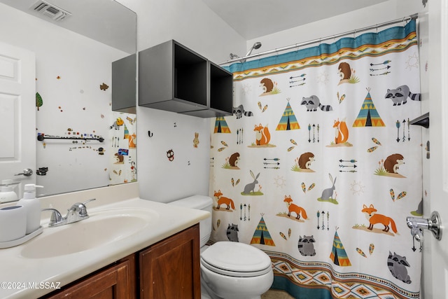 bathroom featuring toilet, vanity, and curtained shower