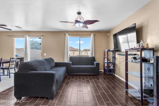 living room featuring ceiling fan, plenty of natural light, and dark hardwood / wood-style flooring