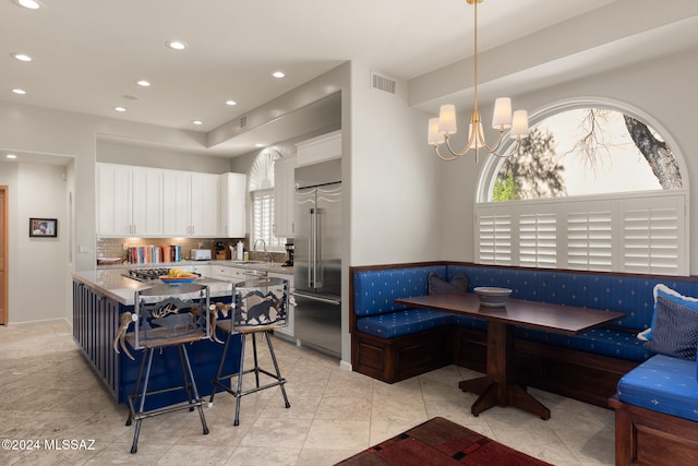 kitchen featuring white cabinets, appliances with stainless steel finishes, a kitchen breakfast bar, breakfast area, and sink