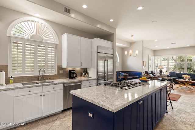 kitchen featuring stainless steel appliances, sink, plenty of natural light, and white cabinets