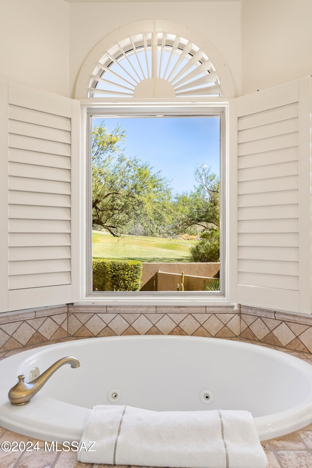 bathroom with tiled tub and a wealth of natural light