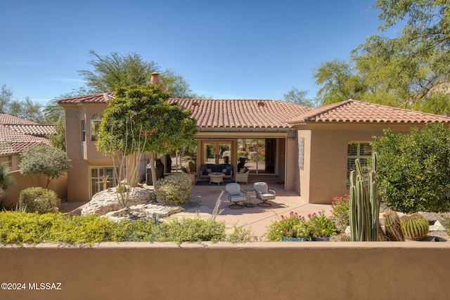 rear view of property featuring outdoor lounge area and a patio