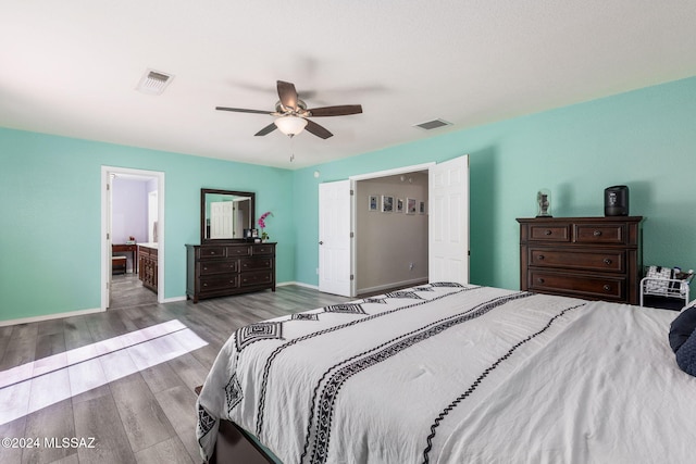 bedroom with ceiling fan, light hardwood / wood-style flooring, and ensuite bathroom