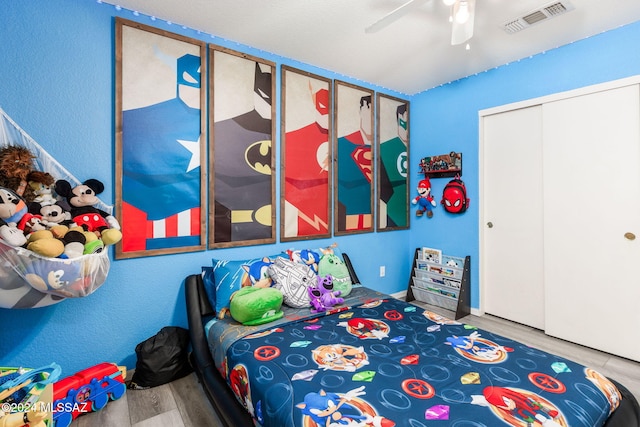 bedroom with hardwood / wood-style floors, a closet, and ceiling fan