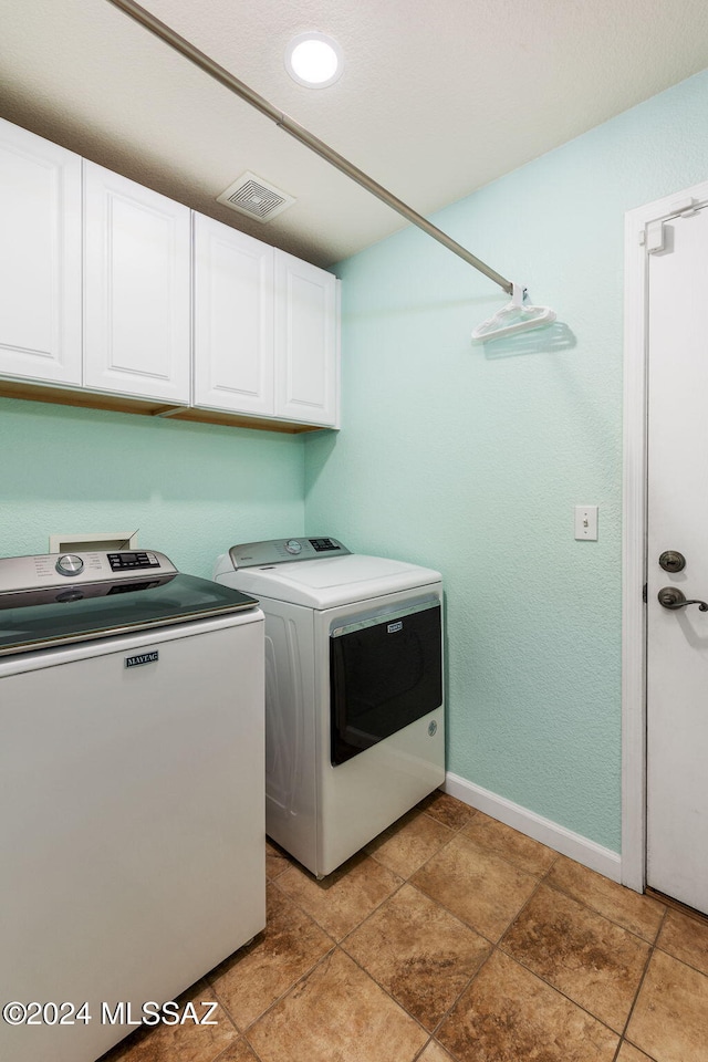 laundry area featuring cabinets and washing machine and clothes dryer