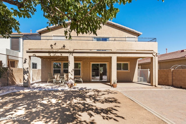 rear view of house with a balcony and a patio