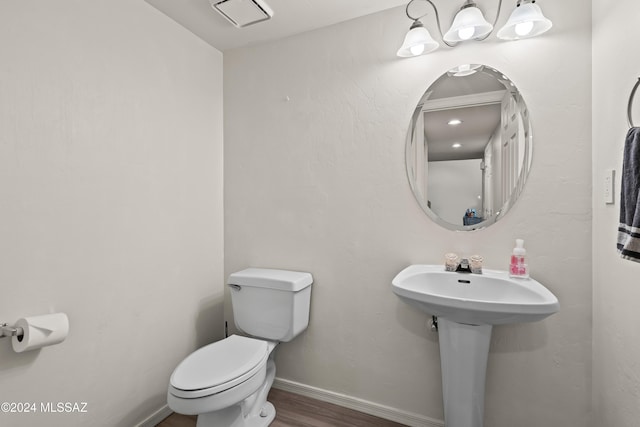 bathroom featuring wood-type flooring and toilet