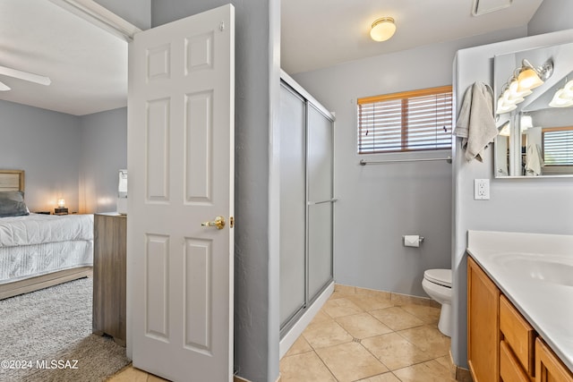 bathroom featuring tile patterned floors, toilet, vanity, and walk in shower