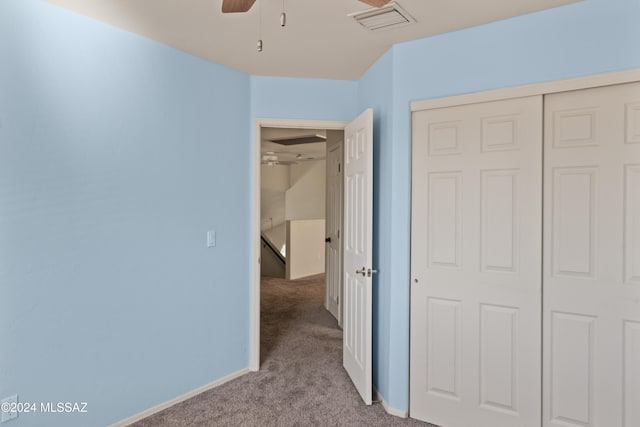 unfurnished bedroom featuring ceiling fan, light carpet, and a closet