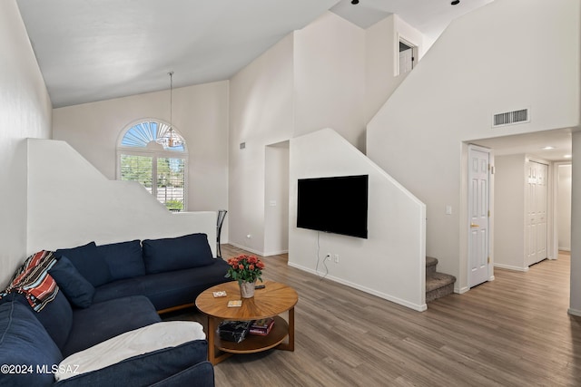 living room with wood-type flooring and high vaulted ceiling