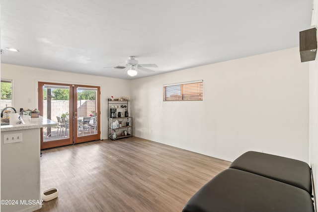 living area with ceiling fan, light hardwood / wood-style floors, and sink