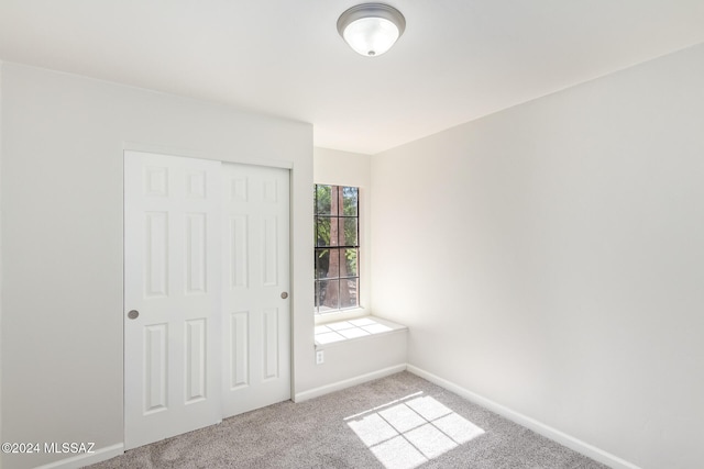 unfurnished bedroom featuring a closet and light carpet