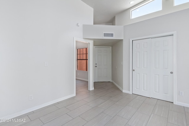 unfurnished bedroom featuring a closet and high vaulted ceiling