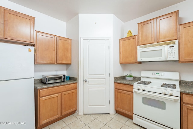 kitchen with white appliances and light tile patterned flooring