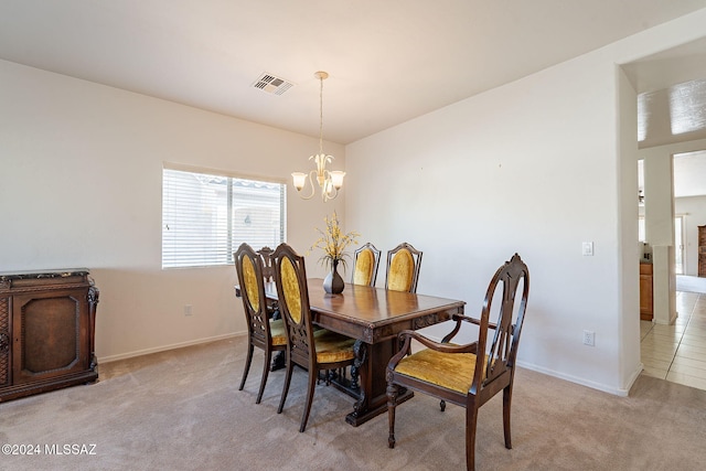 carpeted dining room with a chandelier