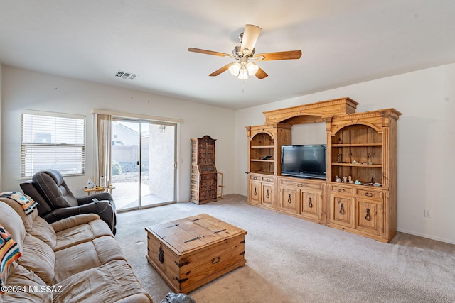 carpeted living room with ceiling fan