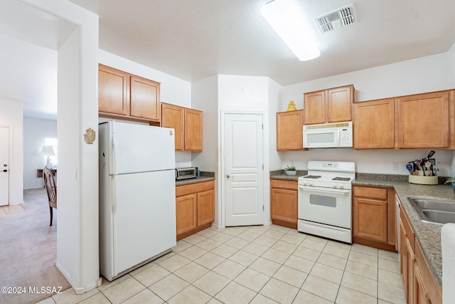 kitchen with sink, white appliances, and light colored carpet