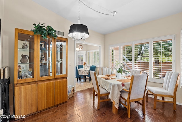 dining space featuring an inviting chandelier and dark hardwood / wood-style flooring