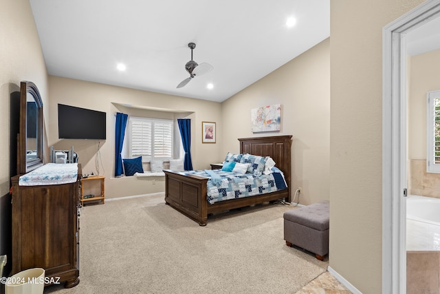 bedroom with ceiling fan, lofted ceiling, ensuite bathroom, and light colored carpet