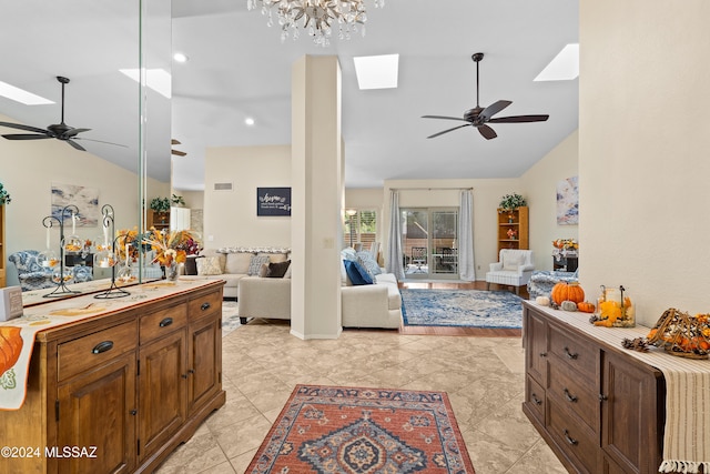 interior space featuring vaulted ceiling with skylight and ceiling fan with notable chandelier