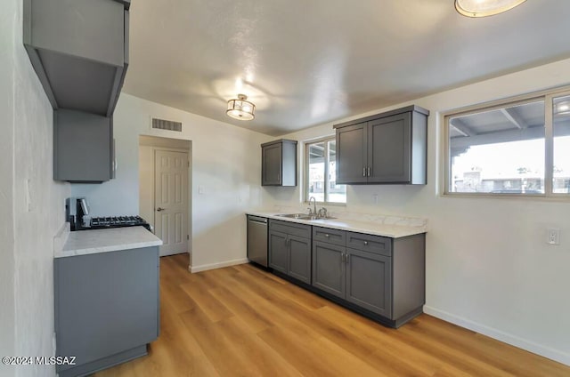 kitchen featuring a sink, gray cabinets, range, visible vents, and stainless steel dishwasher