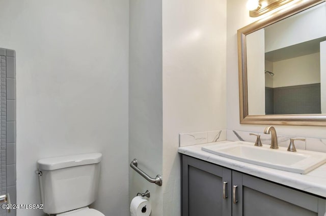 full bathroom featuring toilet, walk in shower, and vanity