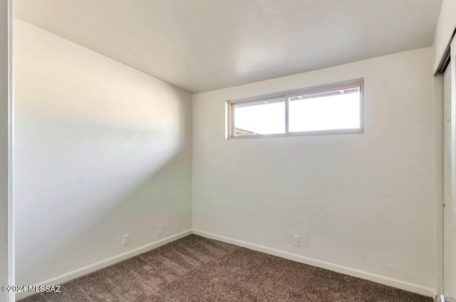 unfurnished room with carpet floors and baseboards