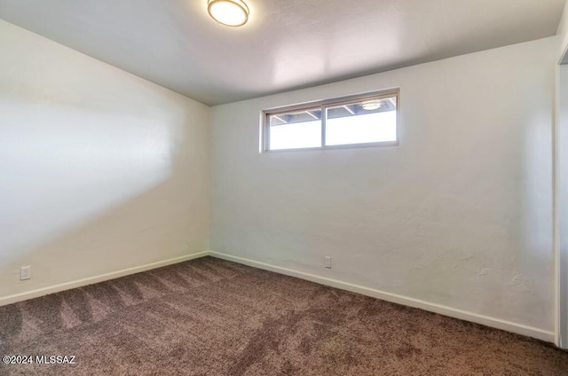 empty room featuring baseboards and carpet