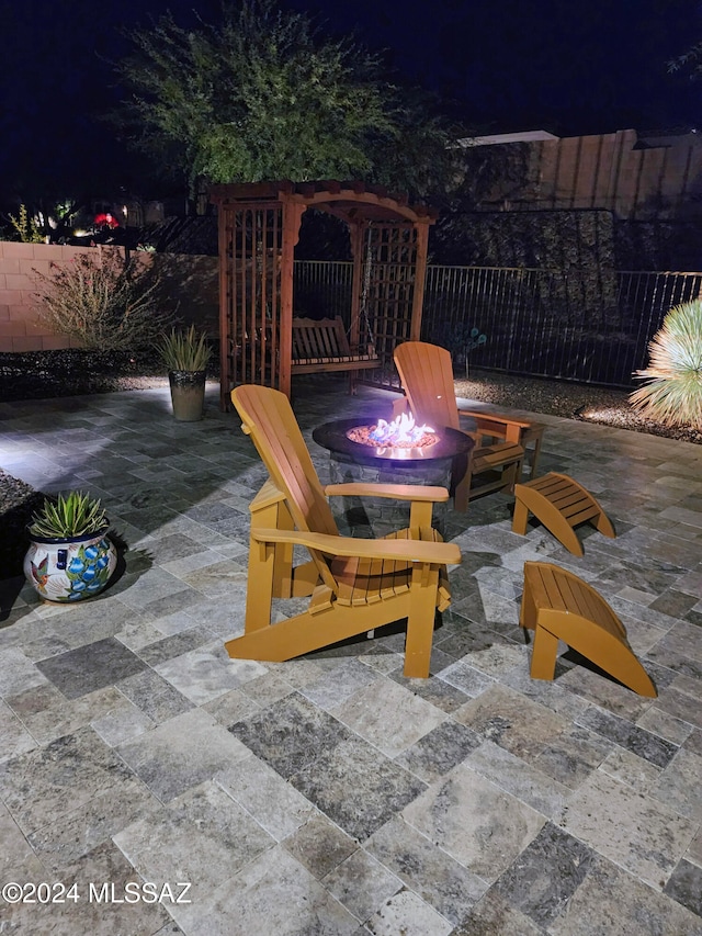 patio at night featuring an outdoor fire pit