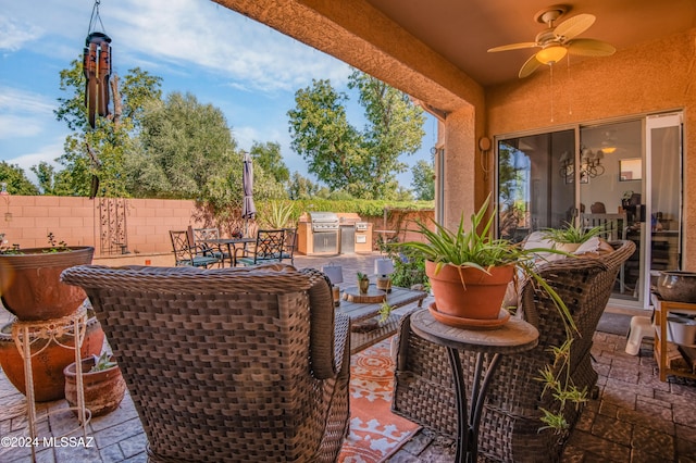 view of patio with area for grilling, ceiling fan, and a grill