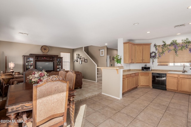 kitchen featuring sink, dishwasher, kitchen peninsula, light tile patterned floors, and light brown cabinets