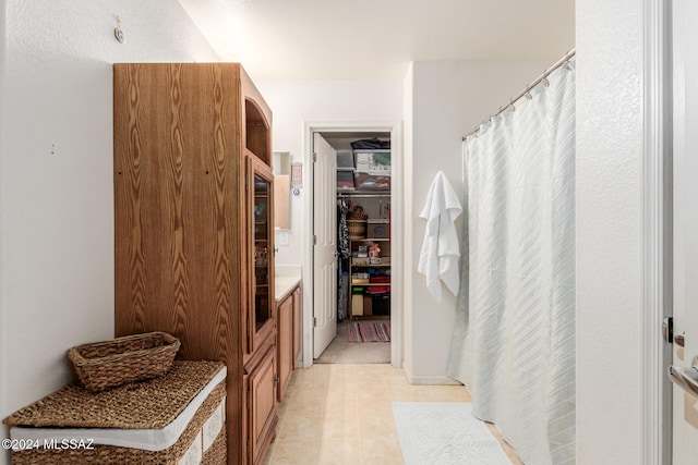 bathroom featuring vanity, curtained shower, and tile patterned floors