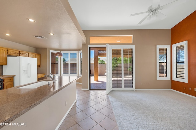 kitchen featuring white fridge with ice dispenser, sink, decorative light fixtures, light tile patterned floors, and ceiling fan