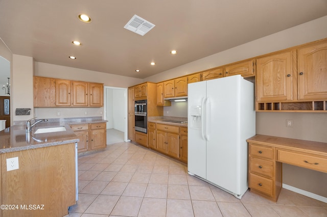 kitchen with light stone countertops, light tile patterned floors, appliances with stainless steel finishes, and sink