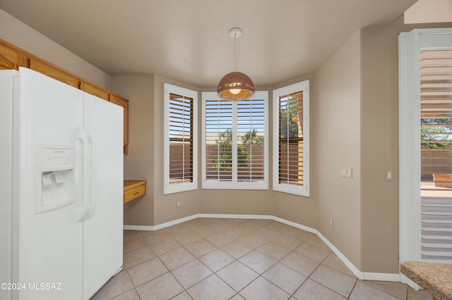 unfurnished dining area with light tile patterned floors and a wealth of natural light