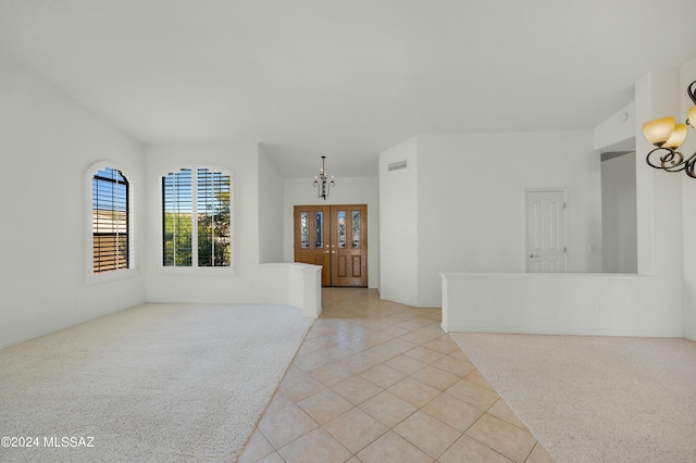 spare room with a notable chandelier and light tile patterned floors