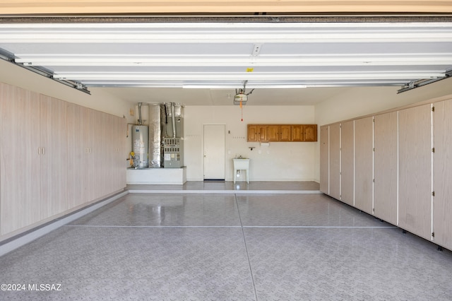 garage featuring a garage door opener, sink, heating unit, and gas water heater