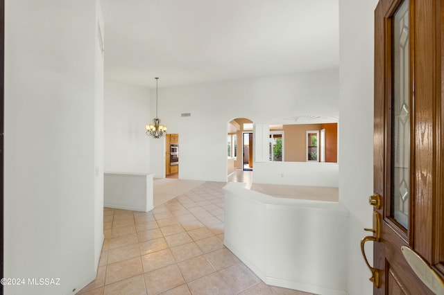 foyer entrance with light tile patterned flooring and an inviting chandelier