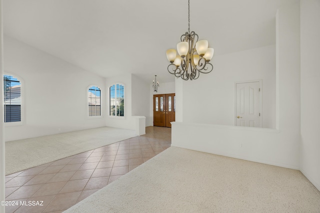 unfurnished room with a wealth of natural light, an inviting chandelier, and light tile patterned floors