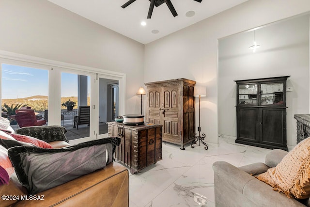 living room featuring a high ceiling and ceiling fan