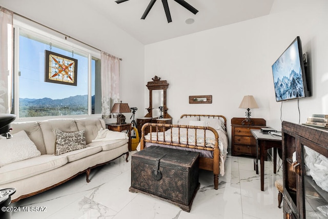 bedroom featuring ceiling fan and a mountain view