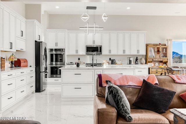 kitchen featuring white cabinetry, stainless steel appliances, and pendant lighting