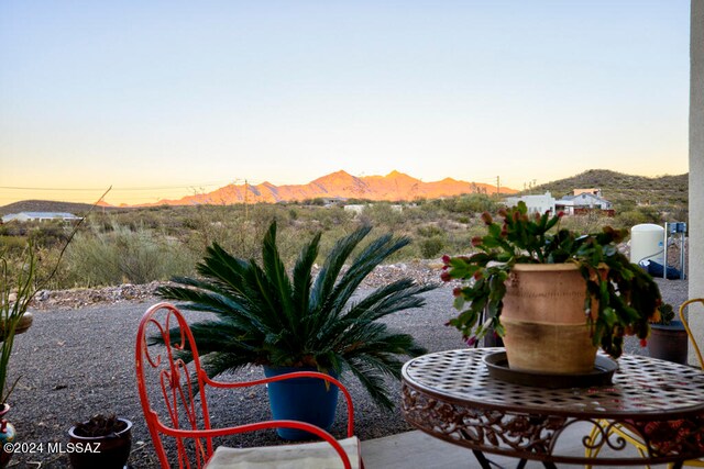 patio terrace at dusk featuring a mountain view