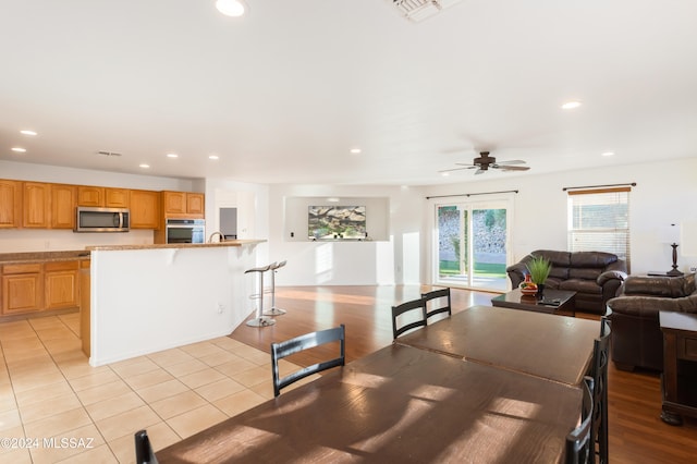 dining space with ceiling fan and light tile patterned floors