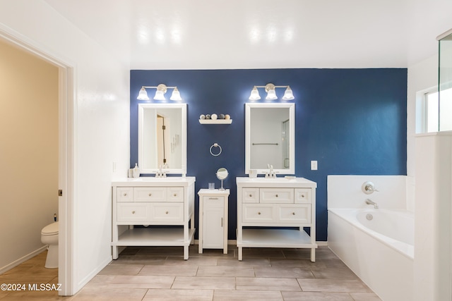 bathroom featuring vanity, a tub, toilet, and hardwood / wood-style floors