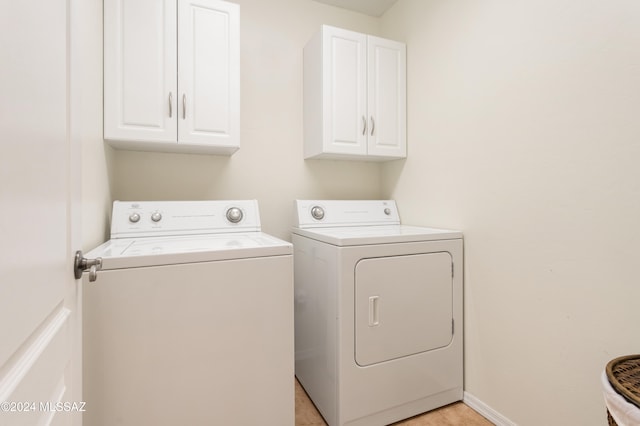 laundry area with independent washer and dryer and cabinets