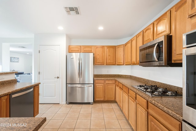 kitchen with appliances with stainless steel finishes and light tile patterned floors