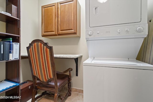 washroom with stacked washer and dryer, cabinets, and light tile patterned flooring