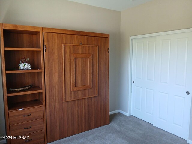 unfurnished bedroom with dark carpet and a closet