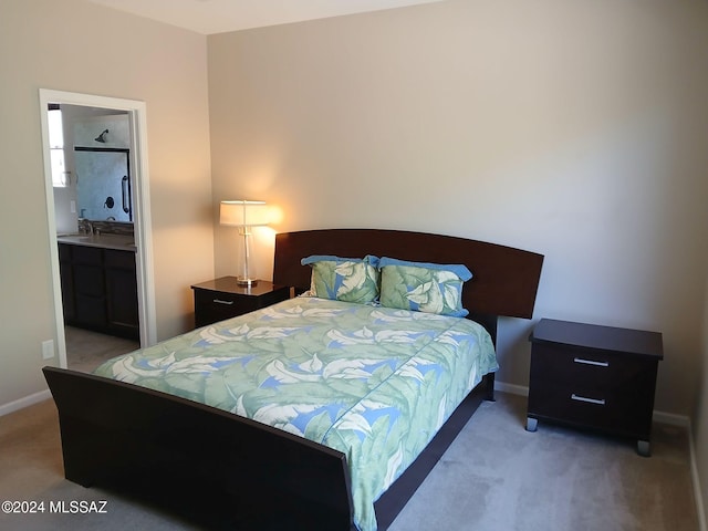 carpeted bedroom with sink and ensuite bathroom